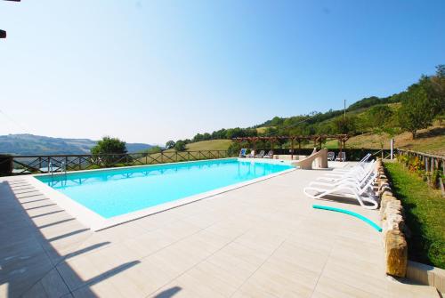 einen Pool mit Liegestühlen neben in der Unterkunft The Assisi at Pian Di Cascina (Umbria with Kids) in Carbonesca