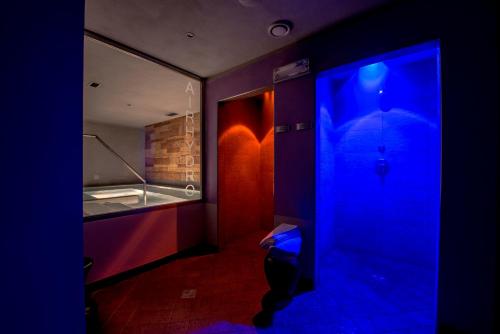 ein blaues Zimmer mit einem Bad mit einem Sonnenschirm in der Unterkunft Albergo Alla Rosa in Canazei