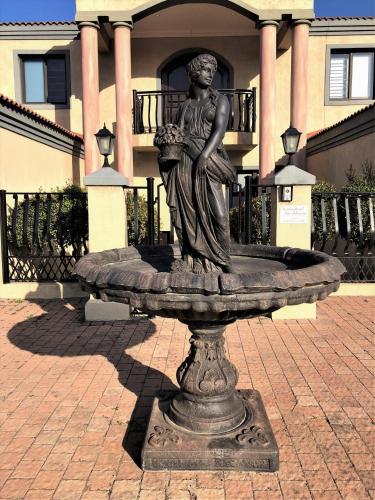 a statue of a woman sitting on top of a fountain at Swanepoel Guesthouse in Jeffreys Bay
