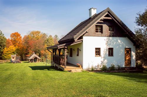 a large white house with a gambrel roof at Zagroda Krasna in Polańczyk