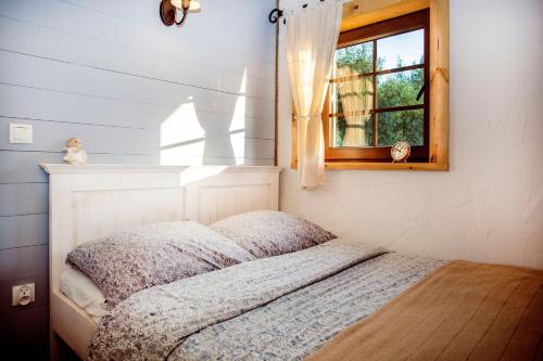 a bedroom with a bed and a window at Zagroda Krasna in Polańczyk