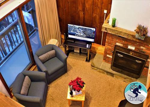 sala de estar con sofás, TV y chimenea en Great Location 3 bedroom condo, Ski home Whiffletree E8, en Killington