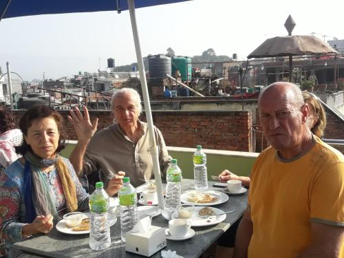 a group of people sitting at a table eating food at Hotel Bhaktapur Inn in Bhaktapur