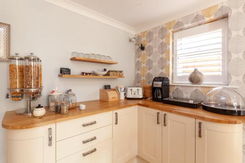 a kitchen with white cabinets and a window at Harriet House B&B in Canterbury