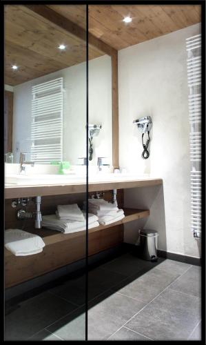 une salle de bain avec deux lavabos et un miroir dans l'établissement Hôtel Champs Fleuris Morzine, à Morzine