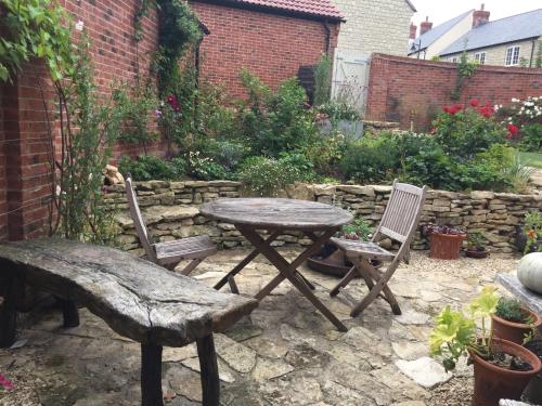 a table and two chairs and a bench in a garden at 34 Grosvenor Drive in Tisbury