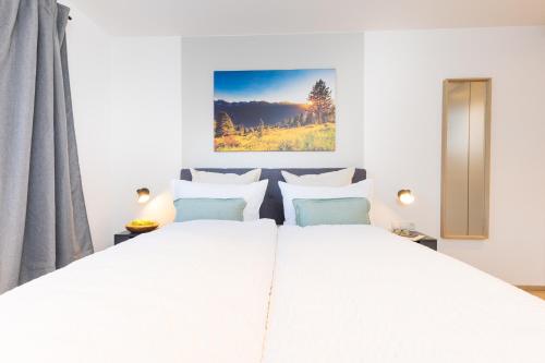 a white bedroom with a large white bed at Easy Living Apartment Ötztal in Sautens