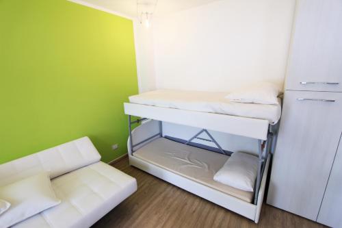 een kleine kamer met een stapelbed en een bank bij Hostdomus - Green Tech Apartment in Sestriere