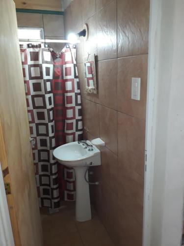 a bathroom with a sink and a red shower curtain at Colores de Fiambala in Fiambala
