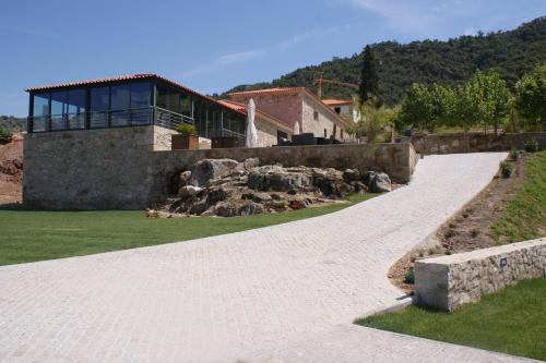 a stone path leading to a house with a building at Quinta da Terrincha in Torre de Moncorvo