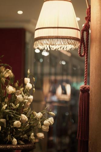 a lamp with a vase of flowers next to a window at Huentala Hotel in Mendoza