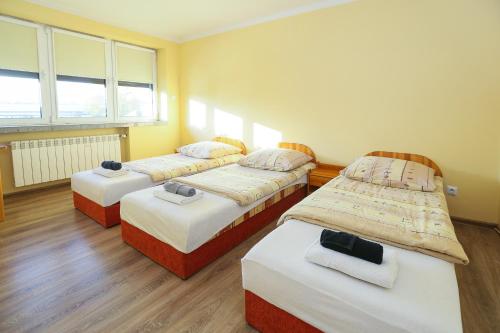 a room with three beds in it with windows at Pokoje gościnne Częstochowa in Częstochowa