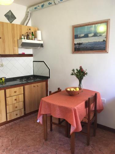 a kitchen with a table with a bowl of fruit on it at Goyo Gomera Apartments in Valle Gran Rey