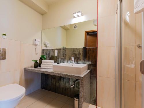 a bathroom with a sink and a shower at VacationClub - Sand Hotel★★★★ Apartament 5 in Kołobrzeg