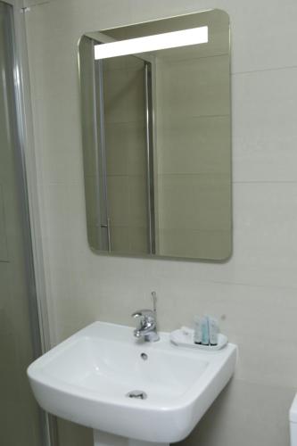 a bathroom with a sink and a mirror at The Spring Bank APARTHOTEL in Preston