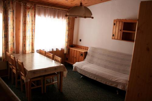 ヴィスワにあるOśrodek Narciarski Stożekのテーブル、ベッド、テーブル、椅子が備わる客室です。