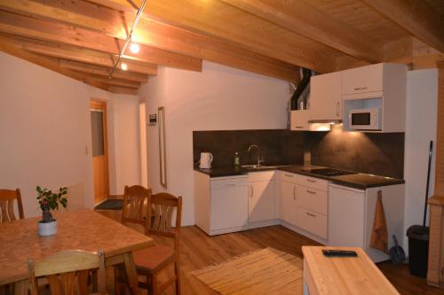 eine Küche mit weißen Schränken und einem Tisch im Zimmer in der Unterkunft Haus Steinacker in Fiss