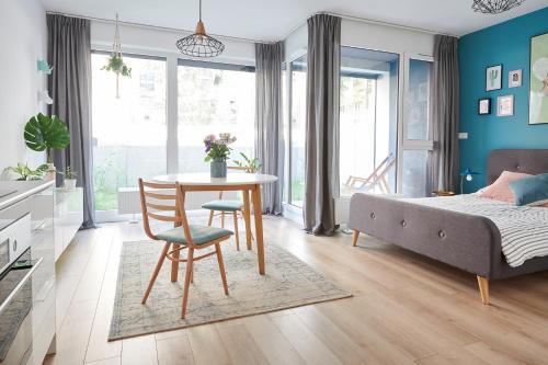 Cet appartement comprend une chambre avec une table et un lit ainsi qu'une chambre aux murs bleus. dans l'établissement Mint Apartment, à Poznań