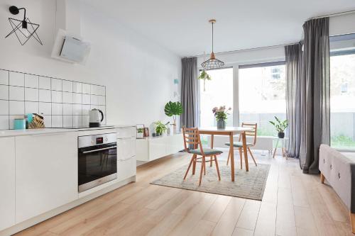 - une cuisine blanche avec une table et des chaises dans l'établissement Mint Apartment, à Poznań