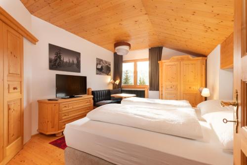 ヴァークラインにあるDesignferienhaus Luxus Bergchalet XXL Ski In-Out Snow Space Wagrain Flachauのベッドルーム(大きな白いベッド1台、テレビ付)