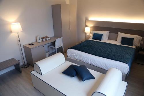una camera d'albergo con due letti e una sedia di Hotel Glis a San Mauro Torinese