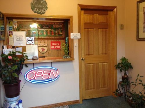 a open sign on a wall next to a door at Cedar Springs Motel in Acton