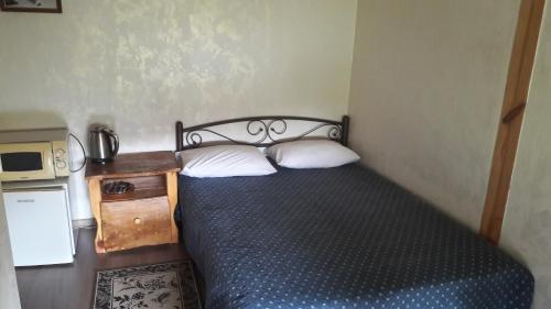 a small bedroom with a bed with two pillows at Mini-hotel Yandrusi in Kamianets-Podilskyi