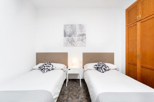 two twin beds in a room with white walls at El Rincón with Teide View III in Icod de los Vinos