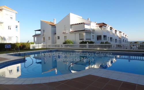 a house and a swimming pool in front of a building at Fuentes de Nerja in Nerja