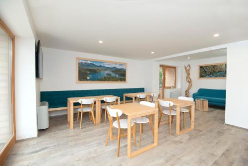 a dining room with tables and chairs and a couch at Vila Alpina in Bled