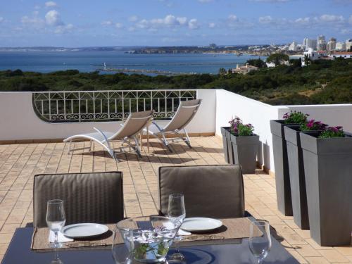 a table and chairs with a view of the ocean at OCEAN TERRACES VILA GAIVOTA J in Ferragudo