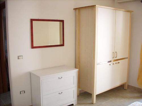 a bedroom with a white cabinet and a mirror at Agriturismoteo in Bernalda