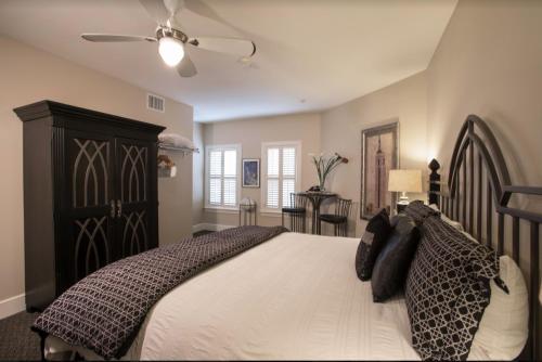 a bedroom with a large bed and a ceiling fan at Gruene River Hotel & Retreat in New Braunfels