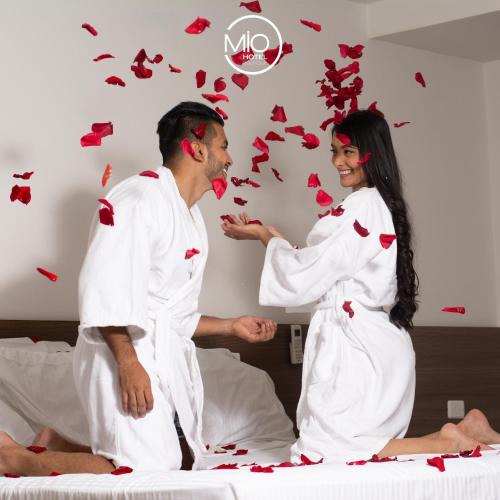 a man and a woman in a bed with butterflies at Hotel Mio Boutique in Cúcuta
