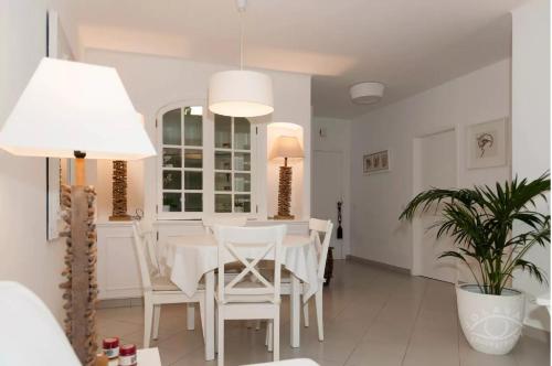 a white dining room with a white table and chairs at OCEAN TERRACES VILA GAIVOTA J in Ferragudo