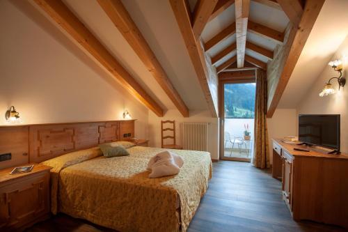 ein Schlafzimmer mit einem Bett und einem TV in einem Zimmer in der Unterkunft Resort Dolce Casa - Family & Spa Hotel in Moena