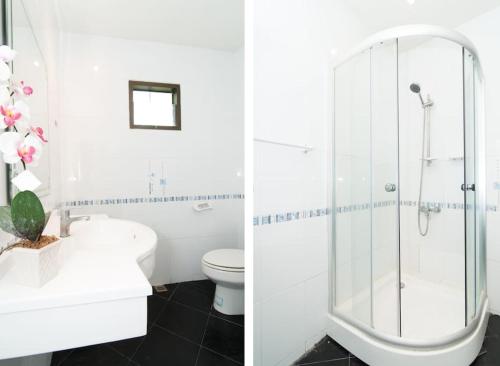 ein weißes Badezimmer mit Dusche und Toilette in der Unterkunft CORNER VILLA - PATTAYA HOLIDAY HOUSE WALKING STREET 4 bedrooms in Pattaya South
