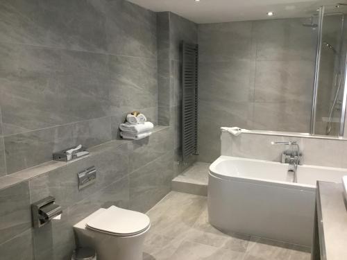 a bathroom with a tub and a toilet and a sink at Seagoe Hotel in Portadown