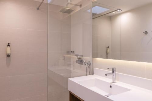 La salle de bains blanche est pourvue d'un lavabo et d'une douche. dans l'établissement Best Western Select Hotel, à Boulogne-Billancourt