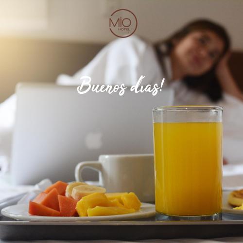 a plate of fruit and a glass of orange juice at Hotel Mio Boutique in Cúcuta