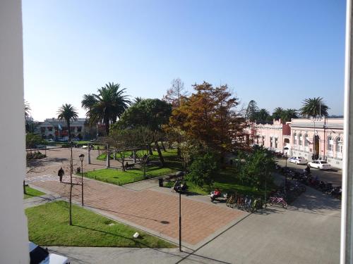 a park with trees and benches and street lights at De la Plaza Hotel in Maldonado