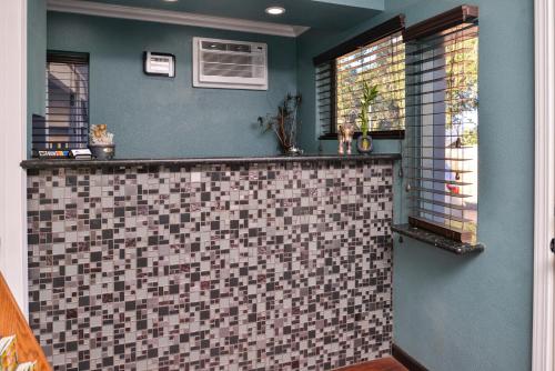 uma casa de banho com um balcão de azulejos e 2 janelas em Americas Best Value Inn and Suites Clearlake em Clearlake