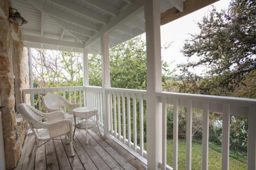 a porch with chairs and a table on it at Gruene River Hotel & Retreat in New Braunfels