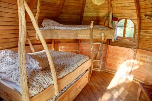 a bedroom with two bunk beds in a log cabin at Insolite dans les arbres Les Ormes, Epiniac in Epiniac