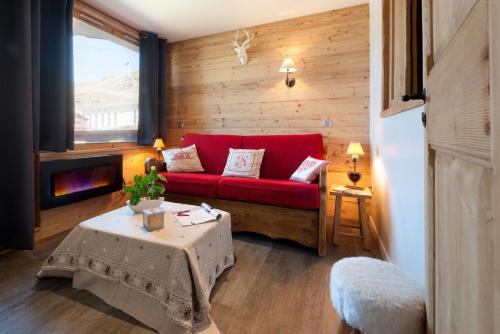 salon z czerwoną kanapą i stołem w obiekcie Nazca J2 w Val Thorens