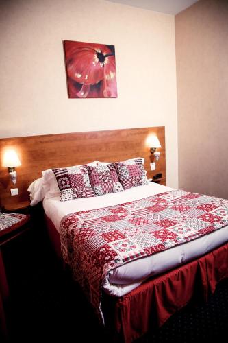 a bedroom with a bed with a red and white bedspread at Au Feu de Bois in Amou