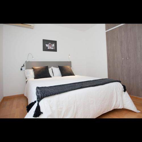a bedroom with a large bed with white sheets and pillows at Pis del Mercat -aire acondicionado en todas las habitaciones y salón- in Deltebre