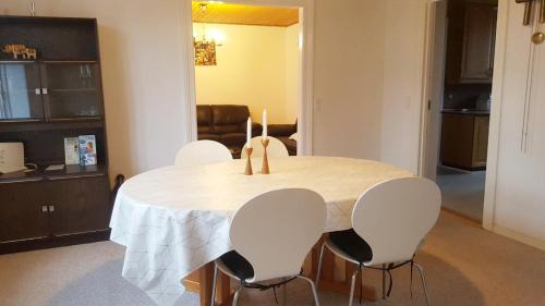 a dining room table with four white chairs around it at Struer Town House in Struer