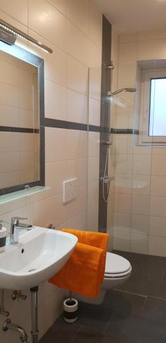 a bathroom with a sink and a toilet and a shower at Ferienwohnungen Trinker - Lungau Karte inklusive in Ramingstein