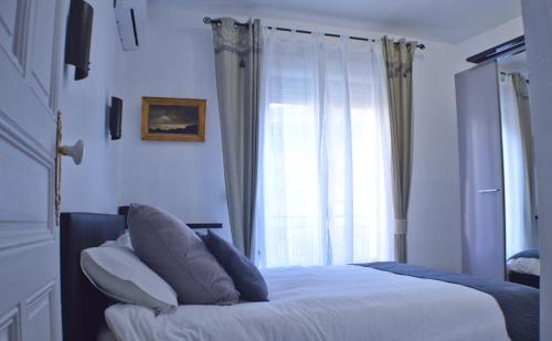 a bedroom with a bed with pillows and a window at BéziersApart *** vivre à la française comme un habitant in Béziers